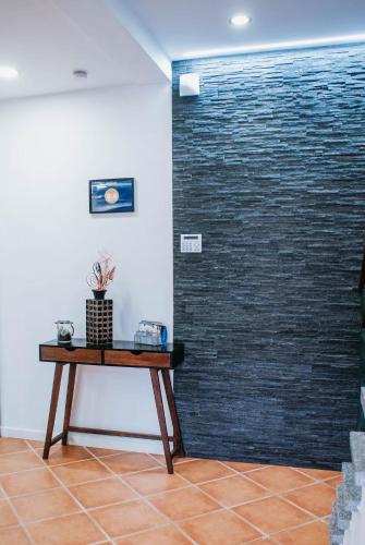 a room with a table in front of a brick wall at Bird’s Home in Aveiro
