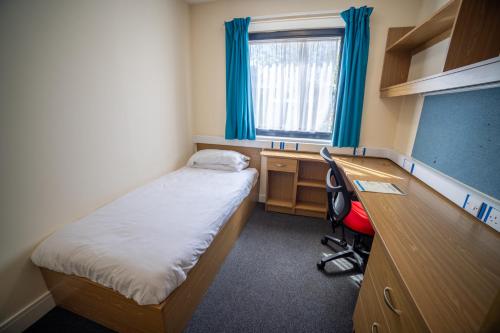 a small room with a bed and a desk and a classroom at University of Essex - Southend Campus in Southend-on-Sea