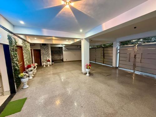 a large empty garage with several pots of flowers at Hotal zora in Rohtak