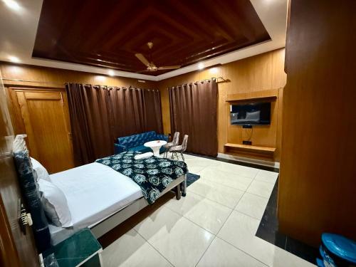 a bedroom with a bed and a table and chairs at Hotal zora in Rohtak