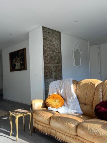 a couch in a living room with a pillow on it at Little Haven Houses Lousada in Lousada