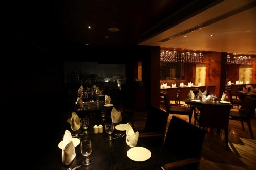 a dining room with tables and chairs in a restaurant at Paradigm Sarovar Portico in Kākināda