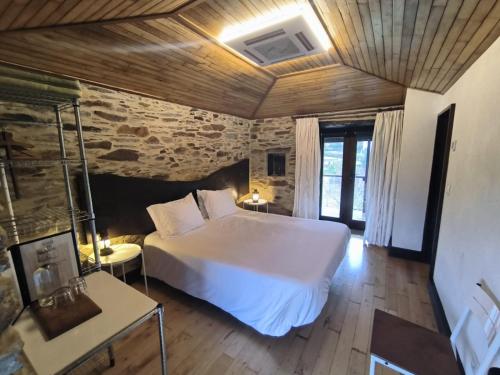 a bedroom with a large white bed in a room at Casa do Porco - Farm Stay & Spa no Douro in Melres