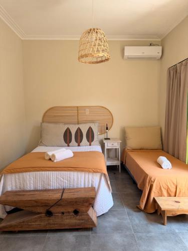 a bedroom with two beds and a chandelier at Casa Josefina Hotel Boutique in Olavarría