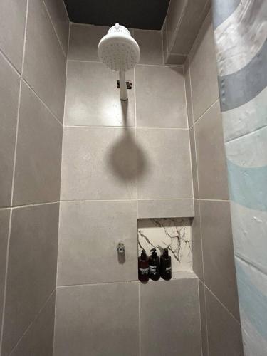 a bathroom with a shower with two pairs of shoes at Mini Suite Aconchego in Garanhuns