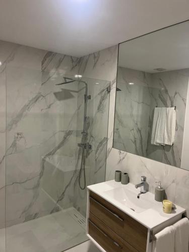 a white bathroom with a shower and a sink at Little Haven Houses Lousada in Lousada