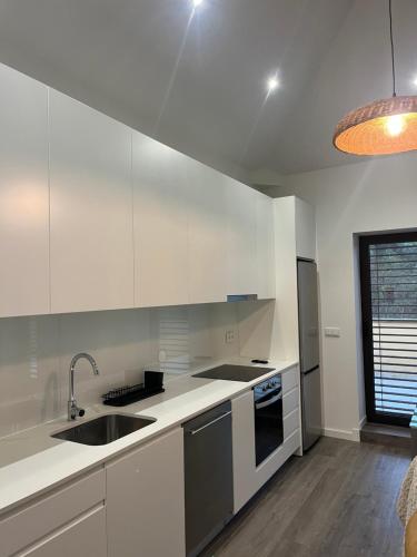 a kitchen with white cabinets and a sink at Little Haven Houses Lousada in Lousada