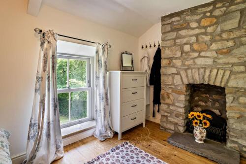 a living room with a stone fireplace and a window at 2 Bed in Blackmill oc-c29623 in Brynmenin