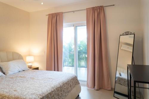 a bedroom with a bed and a large window at Residencial Esprit Caribbean in Bayahibe