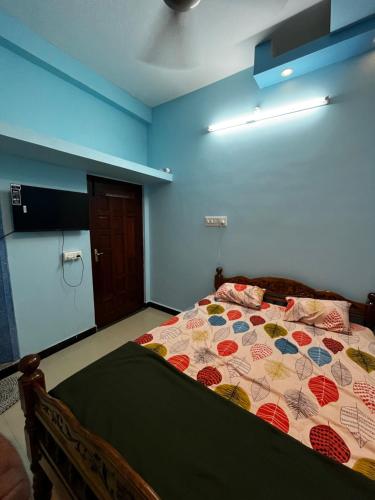 a bedroom with a bed with a colorful quilt on it at Unique Stays in Pondicherry