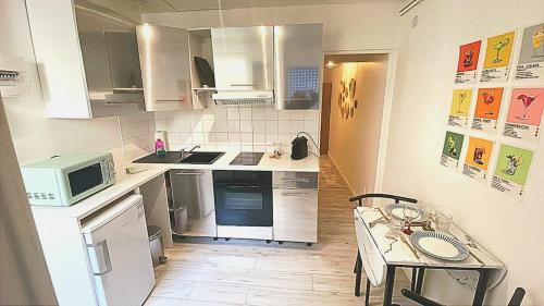 mała kuchnia ze stołem i kuchenką mikrofalową w obiekcie La parenthèse w mieście Saint-Quentin