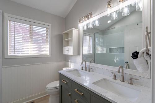 a bathroom with a sink and a toilet and a mirror at Barba Le Lane in Lake Ozark