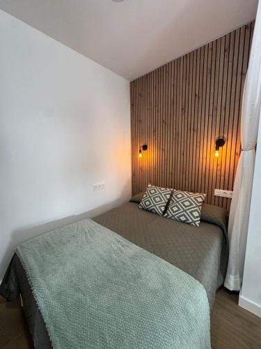 a bedroom with a bed with two pillows on it at Estudio Luminoso AM in Bollullos par del Condado