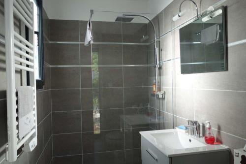 a bathroom with a shower and a sink and a mirror at Chez Christine et Marcel in Nans-les-Pins