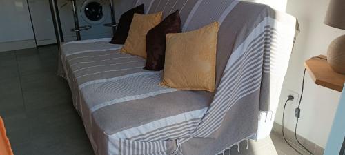 a bed with pillows on it in a room at Chez Christine et Marcel in Nans-les-Pins