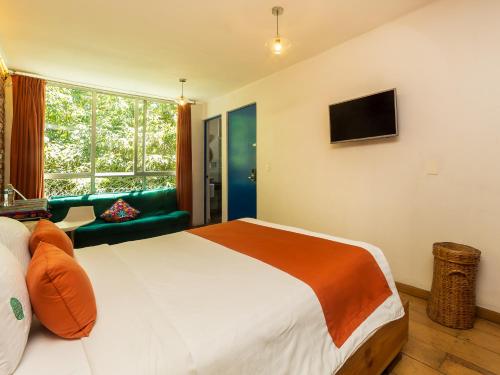 a bedroom with a large bed and a window at Hotel Casa Anzures in Mexico City