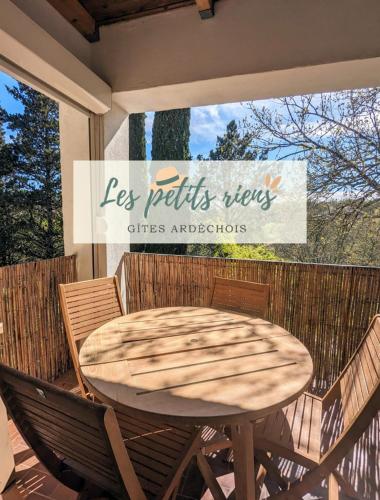 a wooden table and chairs on a patio at Gîte Le Petit rien du Haut - Village classé et plage à pied in Balazuc