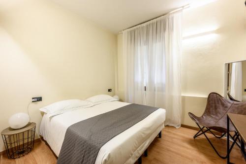 a bedroom with a large white bed and a window at Emilia Studios 2 in Modena
