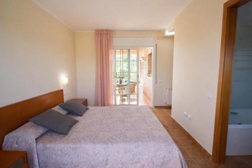 a bedroom with a bed and a door to a patio at Catalunya Casas Tranquil Costa Brava Retreat with private suite! in Sils