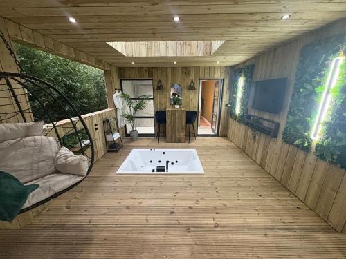 a living room with a tub on a wooden floor at Willow Lodge in Ringwood