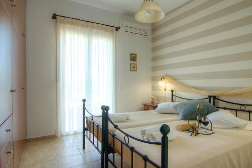 a bedroom with two beds and a striped wall at Villa Afroditi in Agia Triada