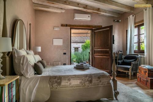 a bedroom with a large bed and a chair at Antica Locanda Lunetta in Màndas