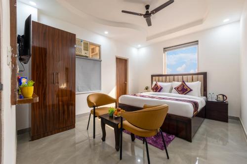 a bedroom with a bed and a table and chairs at Hotel Park Tree I Sec-63A I Noida I Couple Friendly and Corporate Rooms available in Noida