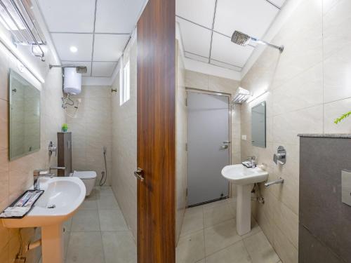 a bathroom with two sinks and a toilet at Hotel Park Tree I Sec-63A I Noida I Couple Friendly and Corporate Rooms available in Noida