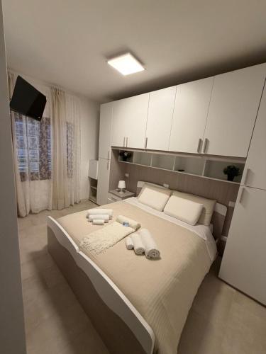 a bedroom with a large bed with towels and cabinets at Il Covo dell'aquila in LʼAquila