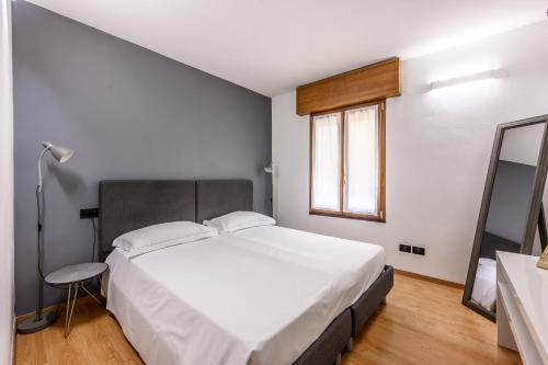 a bedroom with a large white bed and a window at Emilia Studios 4 in Modena