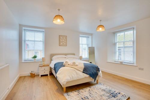 a bedroom with a bed in a room with windows at Apt 2 Armatage Flats, Eyemouth in Eyemouth
