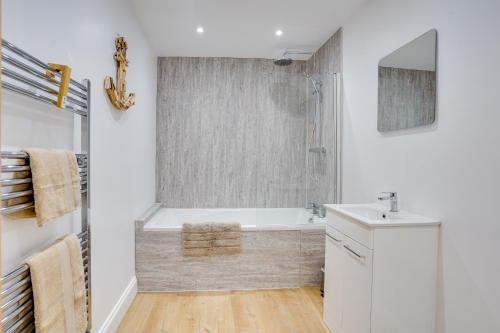 a bathroom with a tub and a sink at Apt 2 Armatage Flats, Eyemouth in Eyemouth