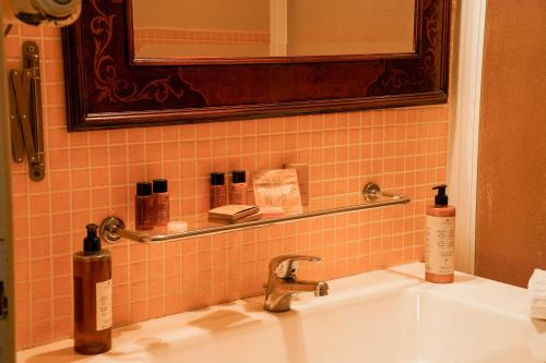 a bathroom sink with two bottles of soap and a mirror at La terrazza nel tempo in Fiuggi