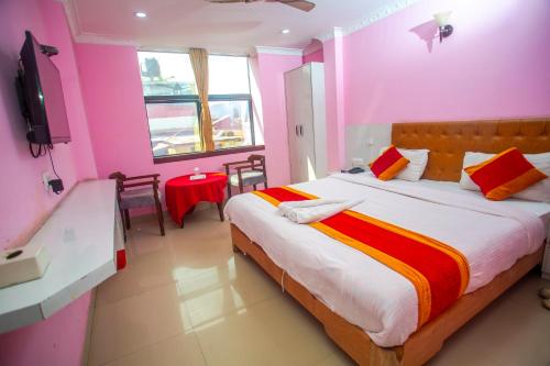 a bedroom with a large bed with pink walls at Hotel Ganga Sagar in Kathmandu