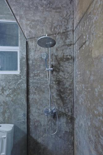 a shower in a bathroom with a toilet at Canal's Edge in Negombo