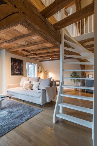 a living room with a white couch and stairs at House of De Swaen Apartments in Breda