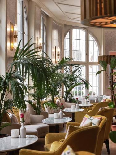 a restaurant with tables and chairs and plants at Hotel Capital in Zagreb