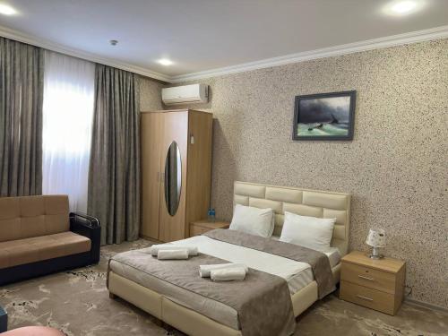 a hotel room with a bed and a couch at Aquapark Quba Hotel in Quba