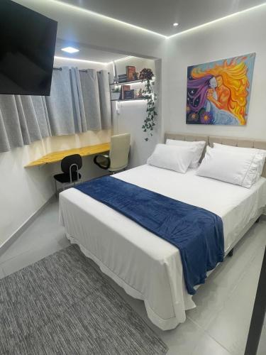 a bedroom with a large bed and a tv at Studio Arte de Cuidar in Campinas