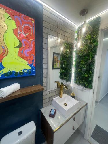 a bathroom with a sink and a mirror at Studio Arte de Cuidar in Campinas