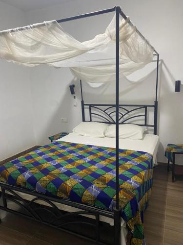 a bedroom with a bed with a canopy at VILLA KEUR BAYE FALL Saly in Sali Nianiaral