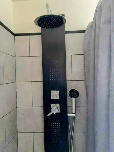 a shower with a black shower head and a shower at Le Calypso pour 4 pers CLIM CONFORT INTERNET PROCHE DE LA GARE in Marmande