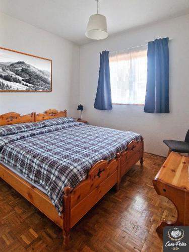 a bedroom with a bed with blue curtains at Casa Polsa 1964 in Brentonico
