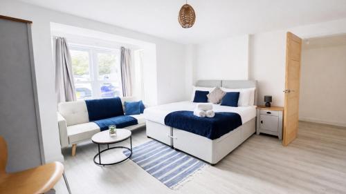 a bedroom with a bed and a couch and a chair at AMETHYST - 4br all with ensuite & parking in Cambridge