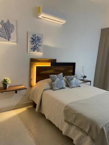 a bedroom with a large bed with blue pillows at Casa de lujo en Playa del Carmen in Playa del Carmen