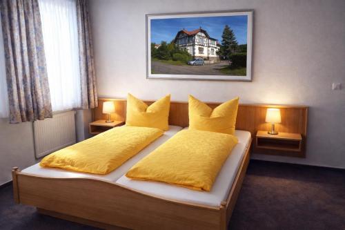 a bedroom with two beds with yellow pillows at Pension Christ in Waltershausen