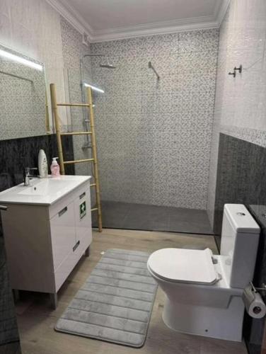 a bathroom with a toilet and a sink and a shower at Alvarenga House in Maia