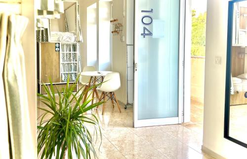 a door leading into a room with a table and a plant at Follow the Sun Boutique Hostel - Pool, Breakfast & Sea Views in St. Julianʼs