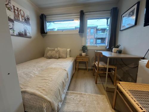 a small bedroom with a bed and a desk at Kongensgate Apartments in Kristiansand