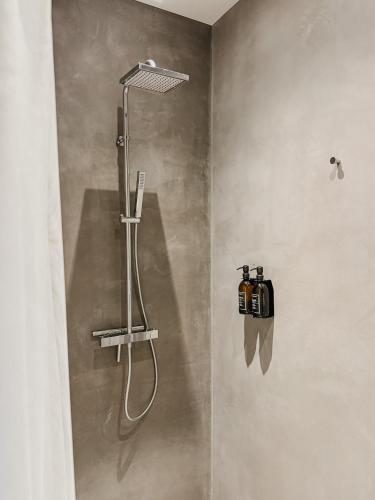 a shower with a shower head in a bathroom at Villa V - Petit Hôtel in Valkenburg